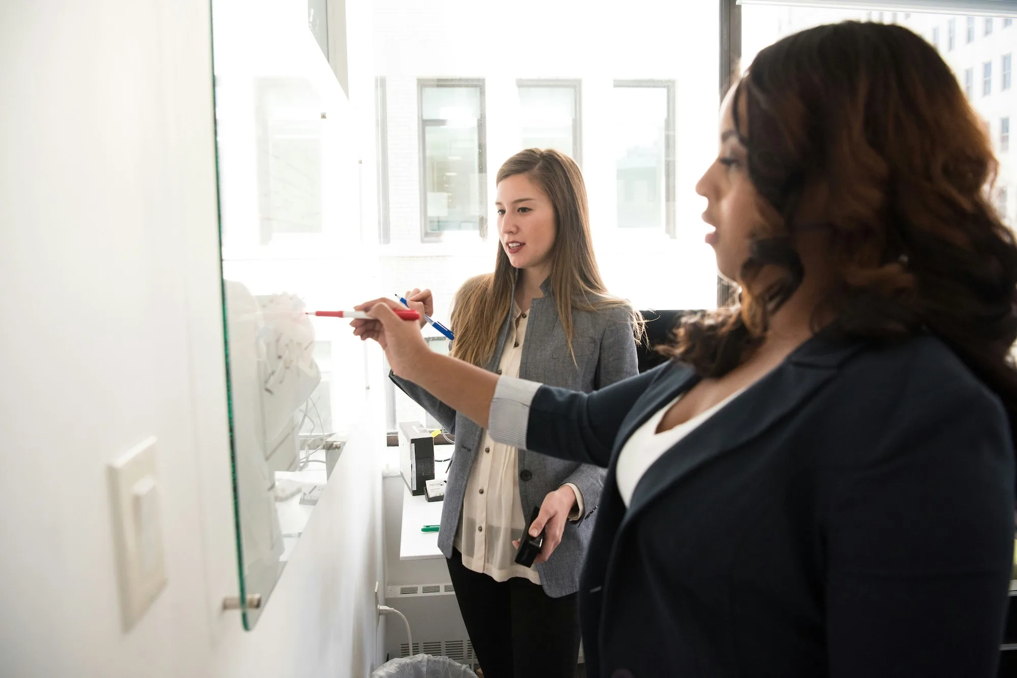 Confident professional woman at her workspace, illustrating what professional development coaching addresses — leadership presence, career growth, and workplace confidence at Taking First