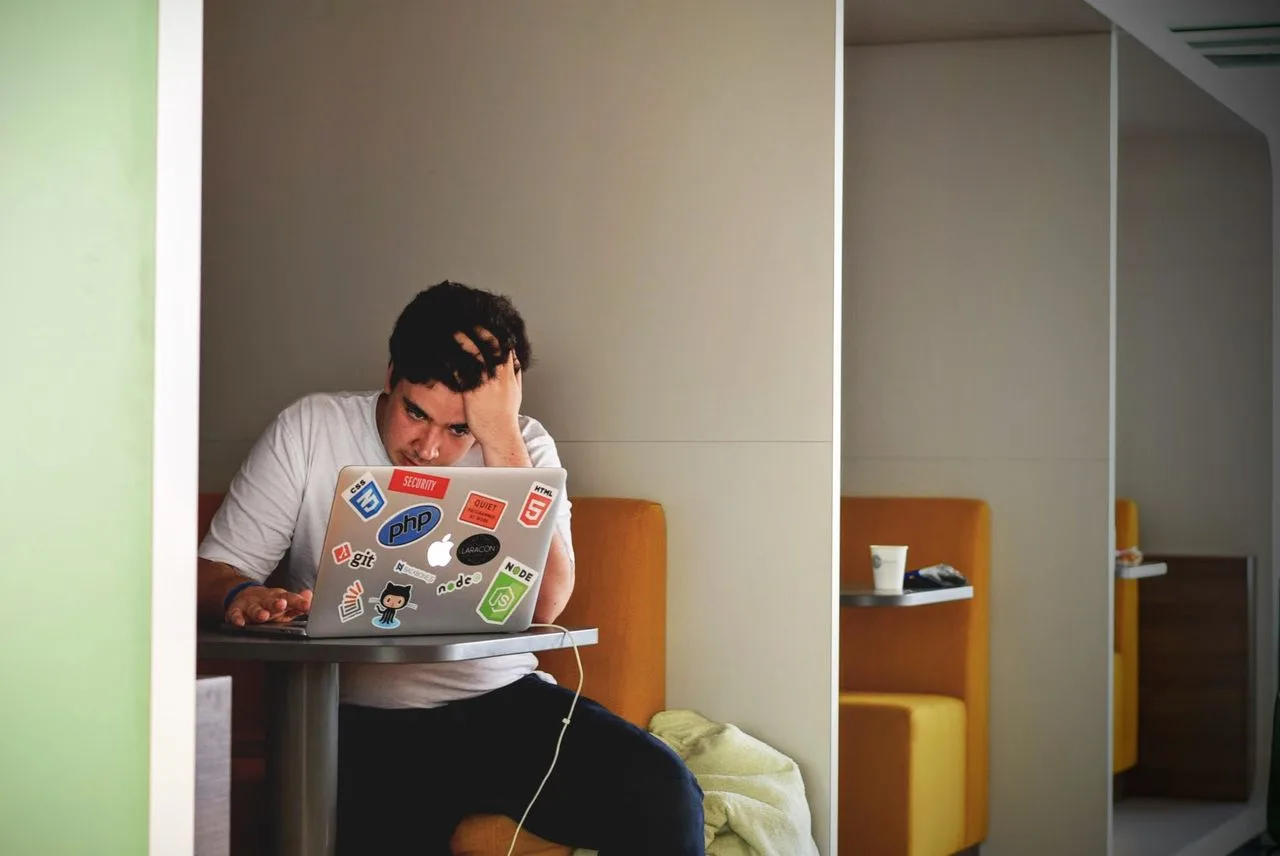 Person frustrated at laptop, showing how self-doubt and overthinking can hold you back